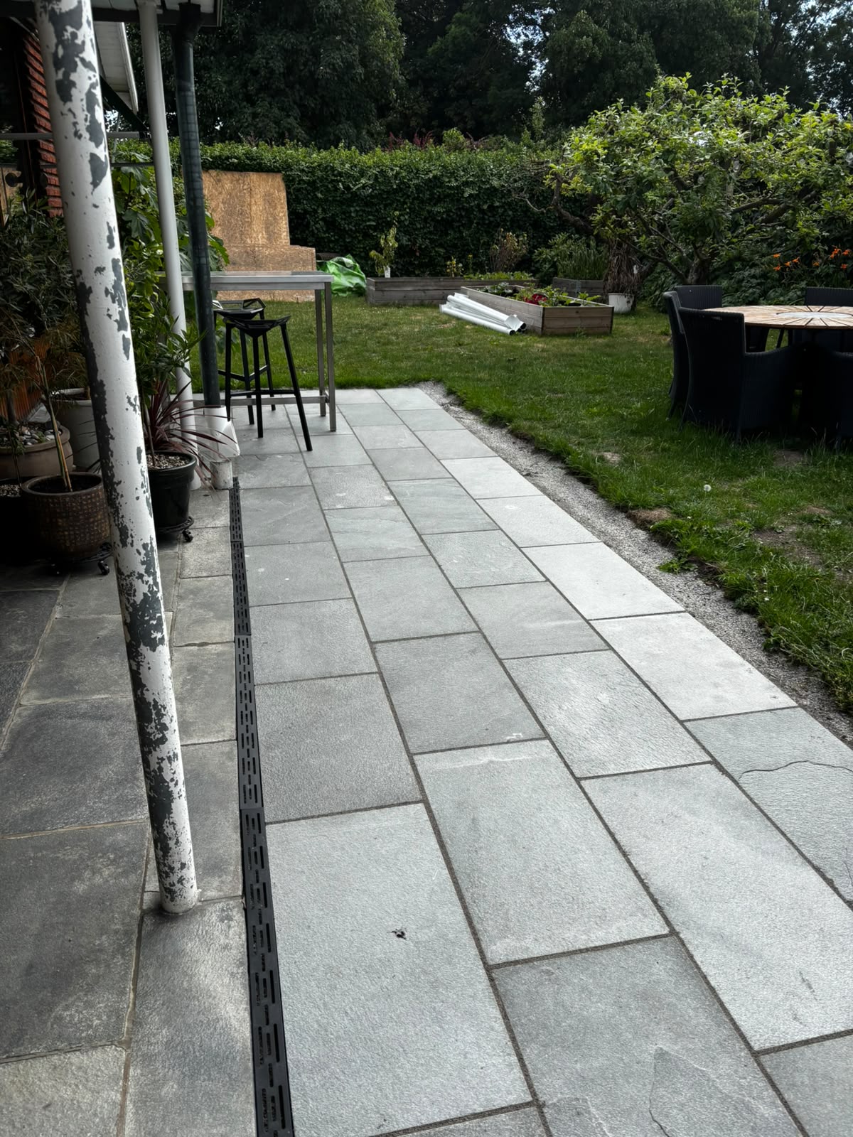 Rectangular stone slab patio leading to raised garden beds